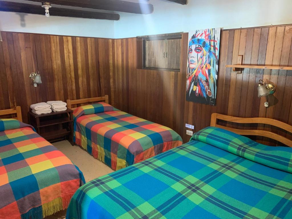 a room with two beds and a painting on the wall at Paipa de ensueño en casa Sochaloma in Paipa