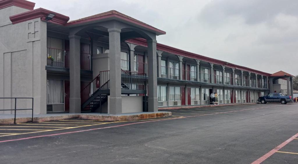 a building with a car parked in front of it at Red Roof Inn Fort Worth West in Fort Worth