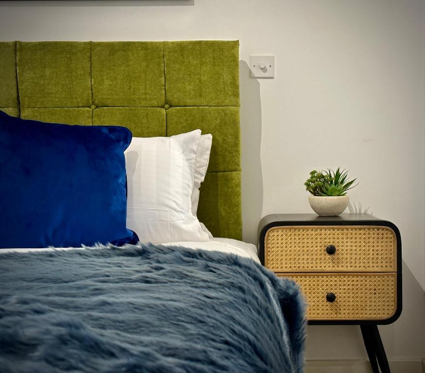 a bedroom with a bed and a plant on a nightstand at Serviced Apartments Nailsea in Nailsea