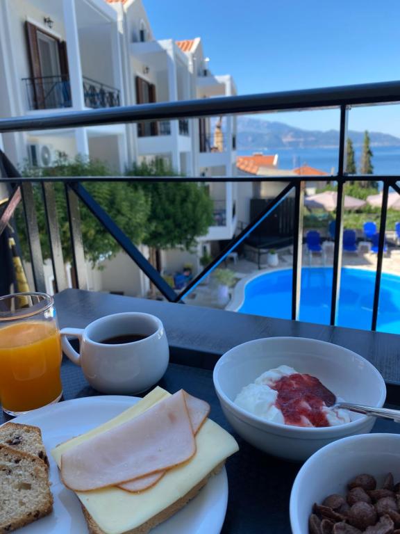 een tafel met ontbijtproducten en uitzicht op een balkon bij Abbey Resort in Monastiraki