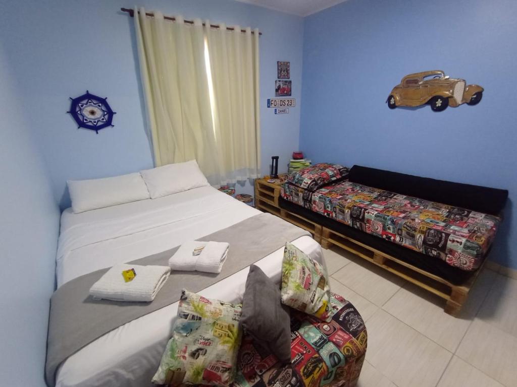 ein Schlafzimmer mit 2 Betten, einem Sofa und einer Uhr in der Unterkunft Loft IMTur in Praia Sêca