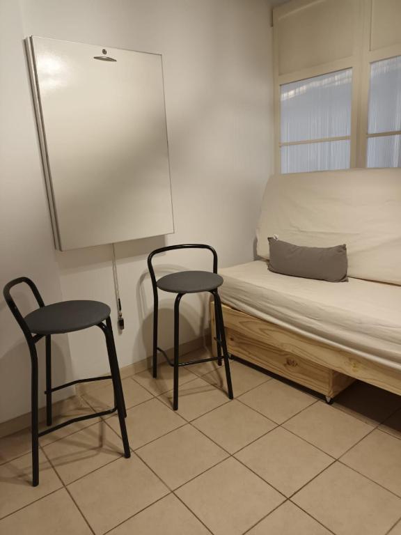 Habitación con 2 sillas y 1 cama con ventana en Departamento Zanzin en Mendoza