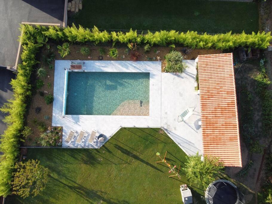- une vue sur la piscine dans la cour dans l'établissement VILLA CADELIA Location de villa familiale, à Cabriès