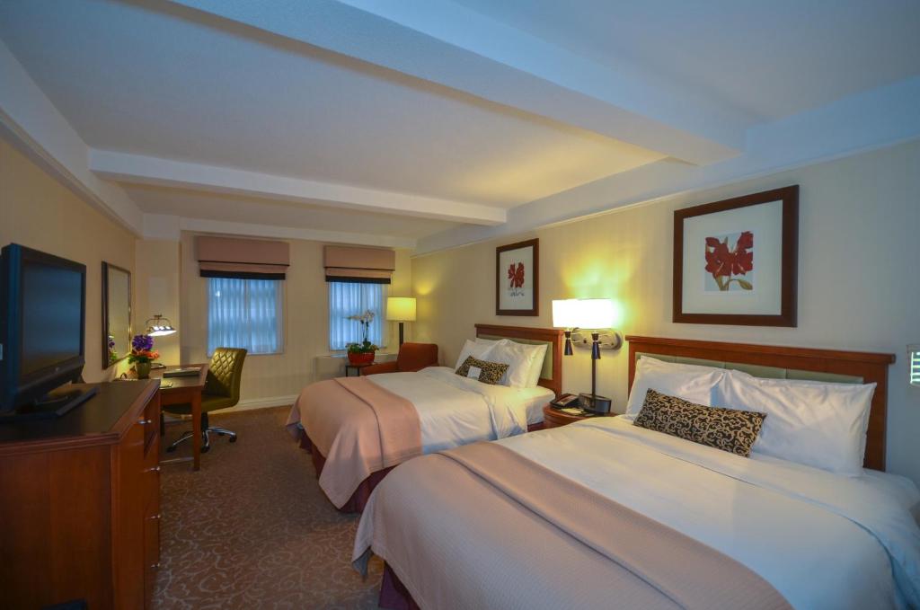 Habitación de hotel con 2 camas y TV de pantalla plana. en San Carlos Hotel New York en Nueva York