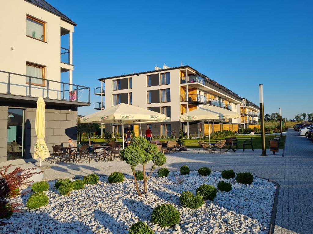 a courtyard with tables and chairs and a building at Apartament KLARA in Sarbinowo