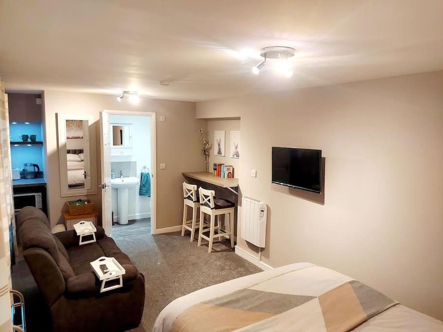 a bedroom with a bed and a living room at Bunny Lodge - Garden view & free parking in Plumtree