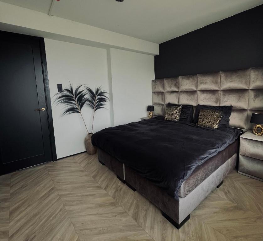 a bedroom with a large bed with a large headboard at Apartment Marmoris in Zandvoort