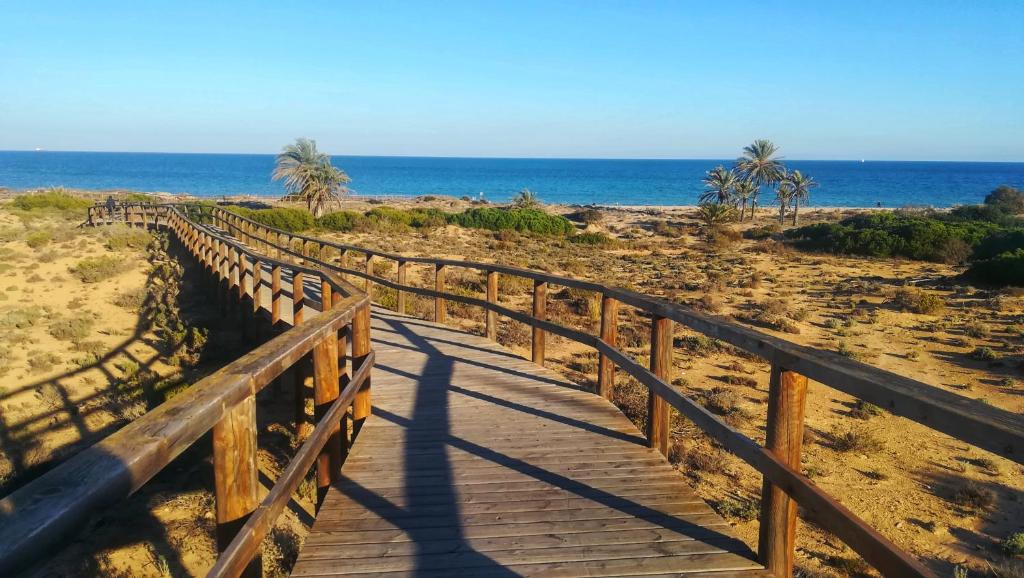 a wooden path to the beach with the ocean in the background at Bungalow Deluxe Gran Alacant in Gran Alacant