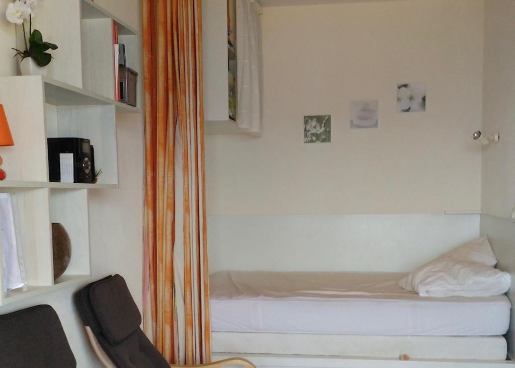 1 dormitorio pequeño con 1 cama y 1 silla en Studio cosy avec vue mer, en Ajaccio