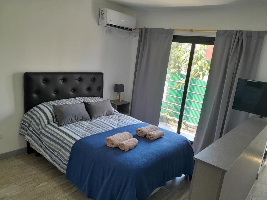 1 dormitorio con 1 cama con 2 toallas en París 2 Monoambiente en Rosario