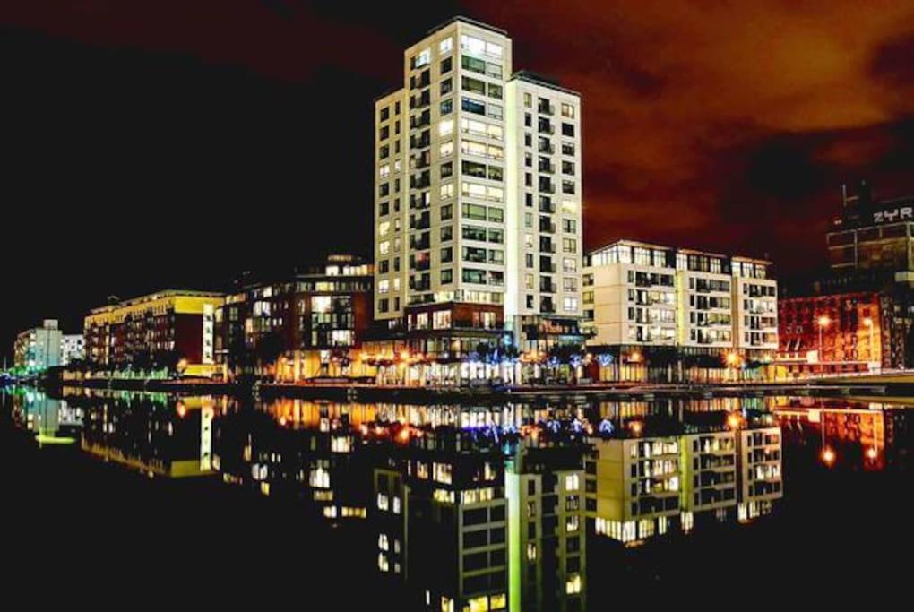a city skyline with a tall building at night at Waterfront Luxury in Dublin