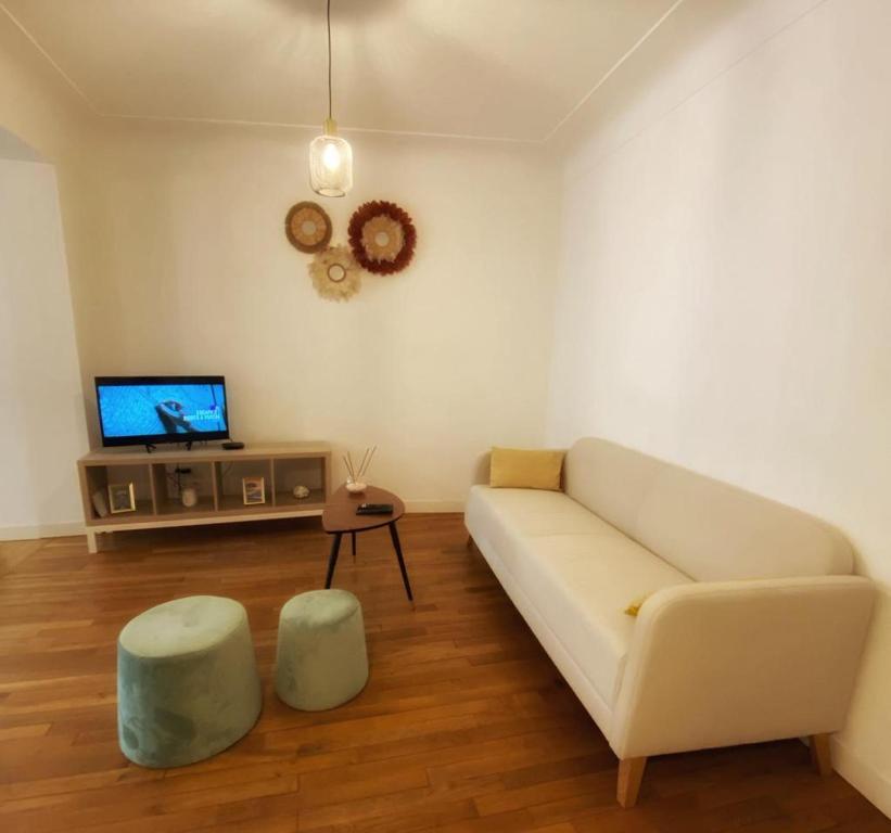 a living room with a white couch and a tv at LE PERCHOIR-POITIERS-LaConciergerie in Poitiers
