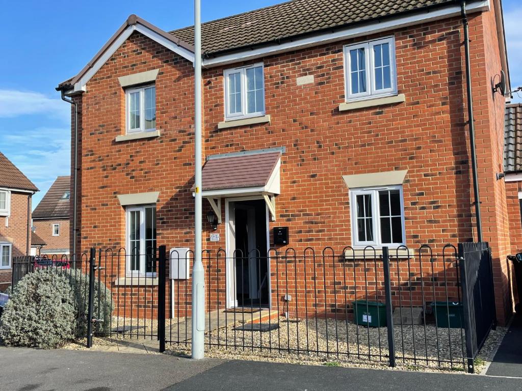 a brick house with a fence in front of it at Stunning Large Detached Gloucester, 4 beds, 3 bedroom, 2 bathroom property, Nr Chelt, The Docks and Quays sleeps 6 in Gloucester