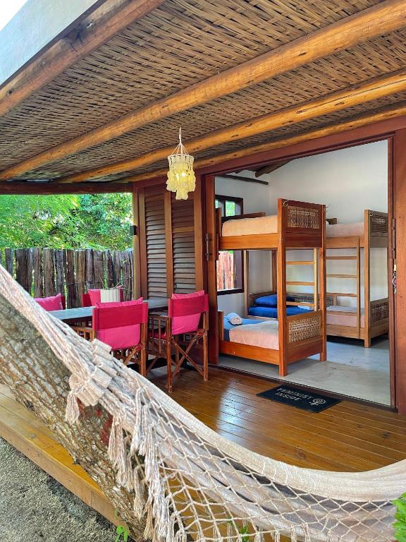 uma rede de descanso num quarto com um quarto e uma cama em Vulva Caraíva Hostel e Pousada para Mulheres em Caraíva