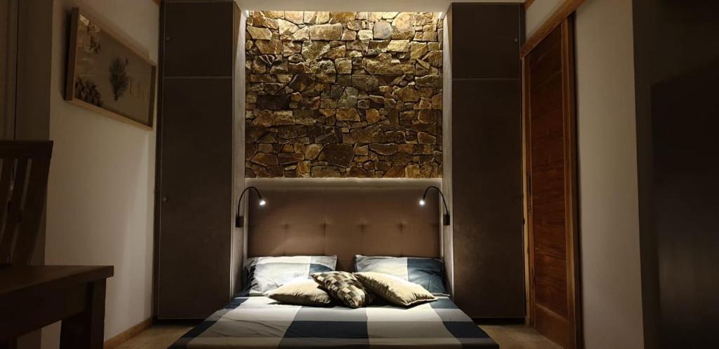 a bed in a room with a stone wall at 5 star Smart studio 30m2 in Flic-en-Flac