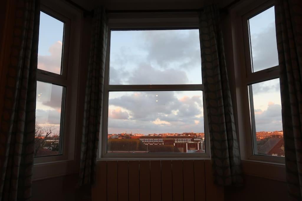 three windows in a room with a view of a city at Stylish Margate apartment in Margate