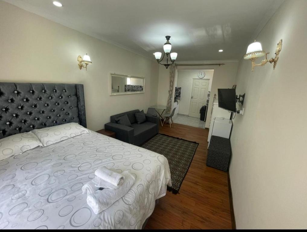 a bedroom with a bed and a living room at Tia Maria cottage in Cape Town