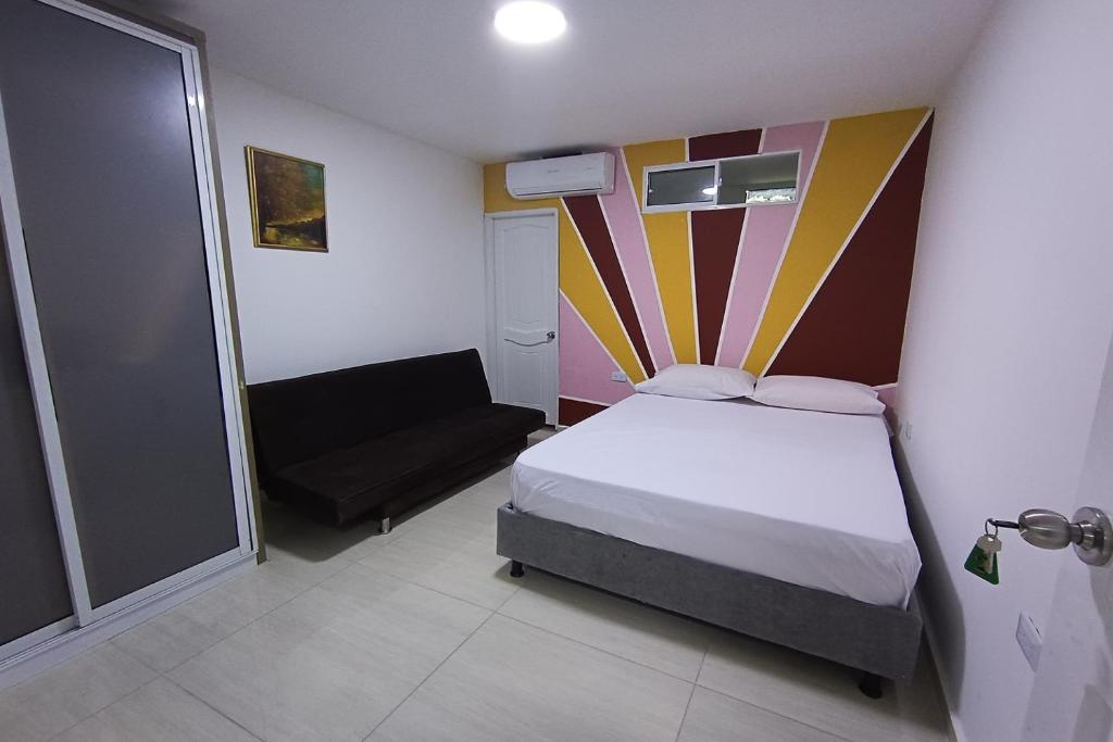 a small bedroom with a bed and a chair at Ayenda Brisas del Rio in Barranquilla