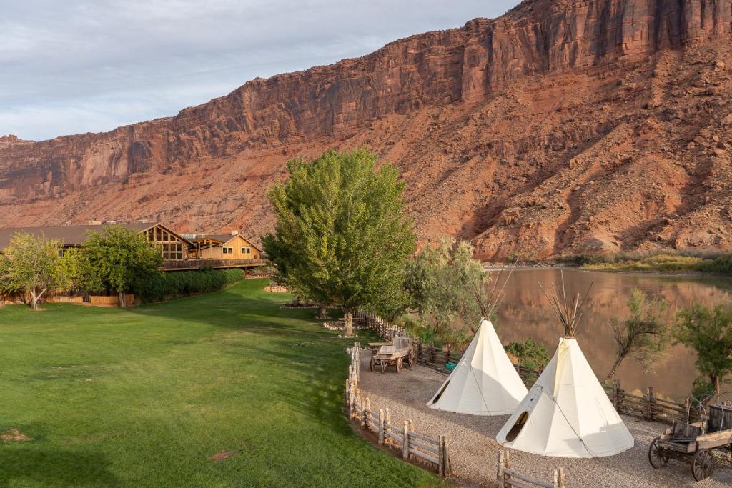 a group of tents on a lawn next to a mountain at Red Cliffs Lodge in Moab