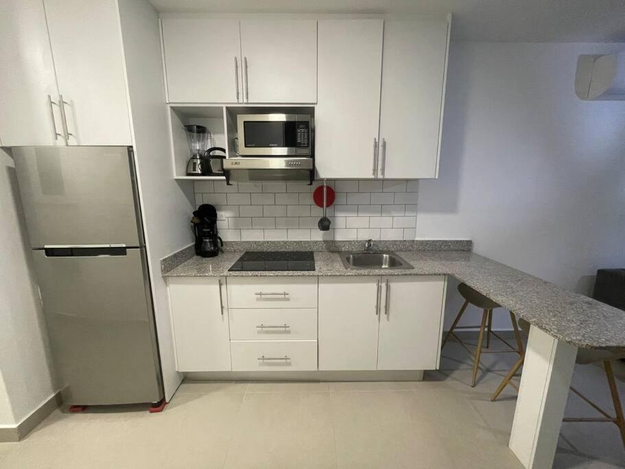 a kitchen with white cabinets and a stainless steel refrigerator at 2br aptSurrounded by history with Modern Amenities in Panama City