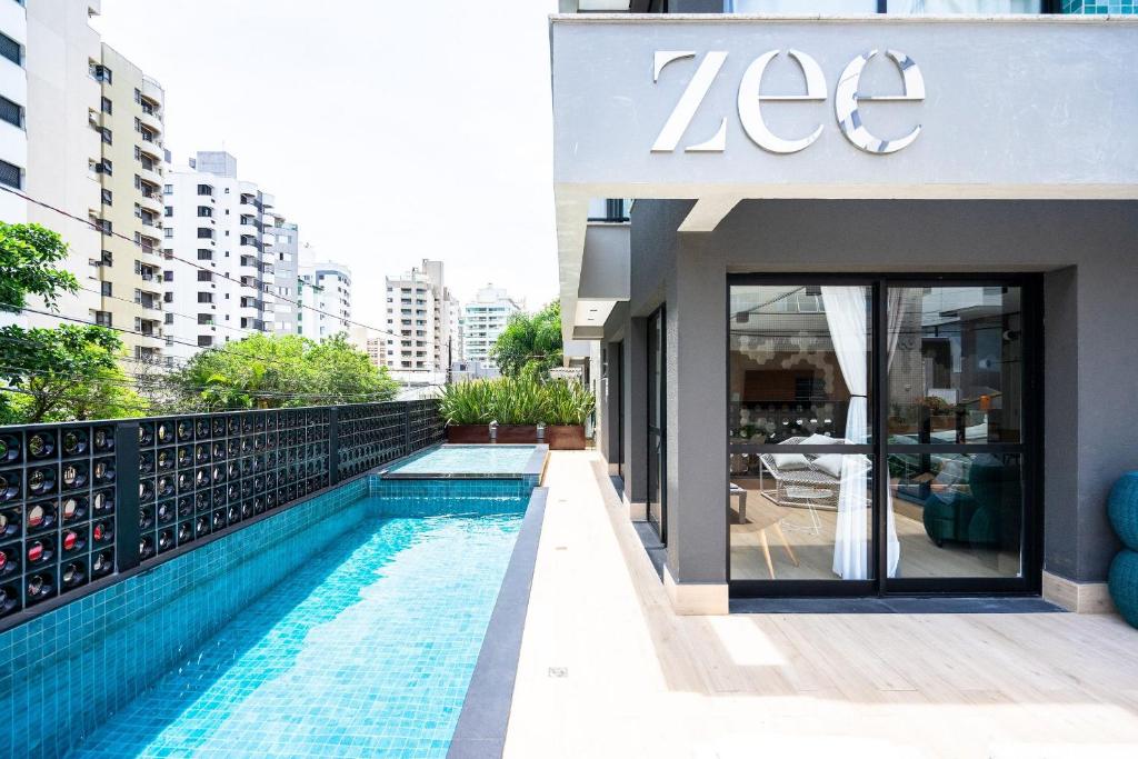 a building with a swimming pool in front of a building at ZEE Studios a 200m da beira-mar norte in Florianópolis