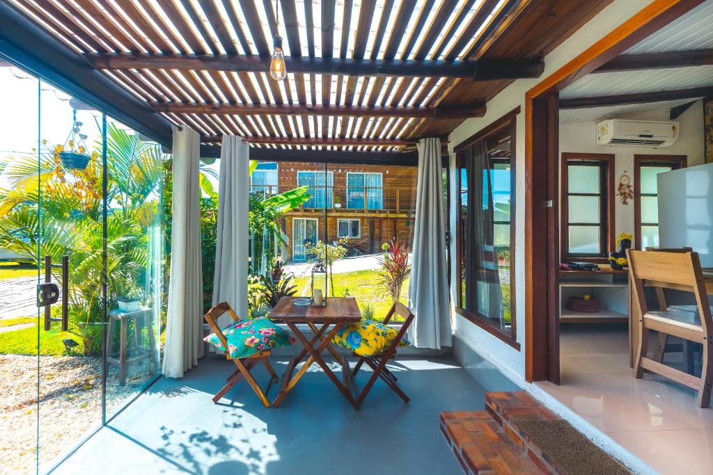 un patio con mesa y sillas en un porche en Casa Natureza Praia do Rosa, en Imbituba