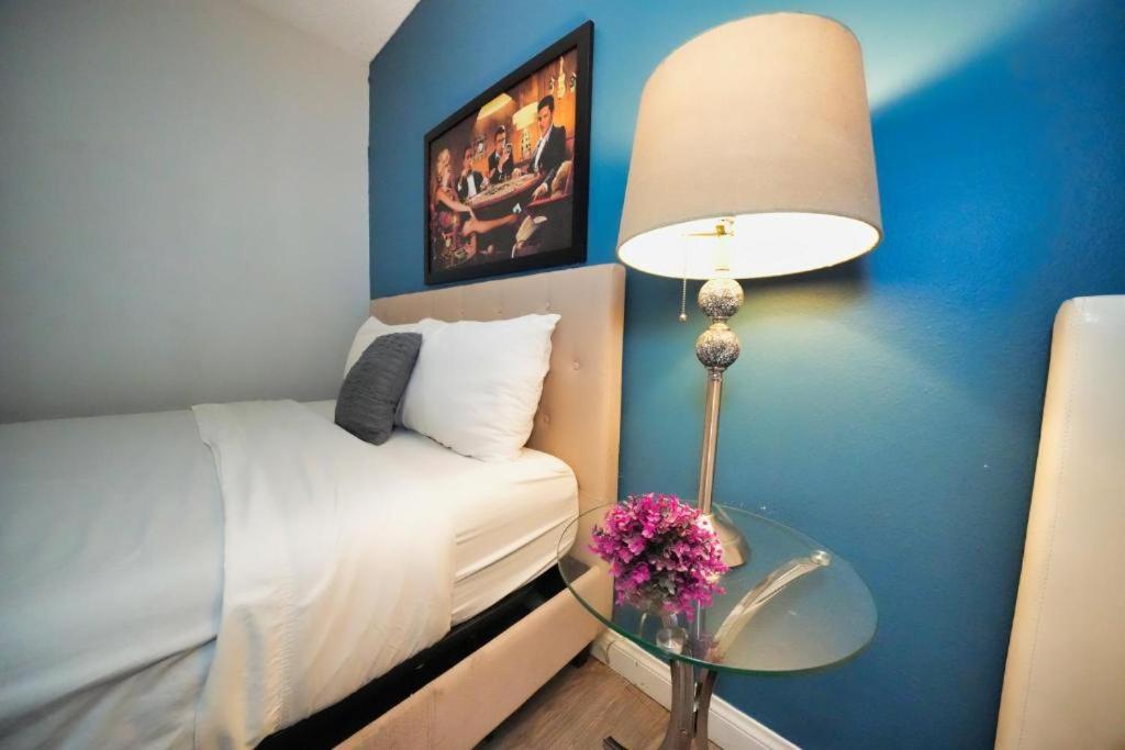 een slaapkamer met een bed en een tafel met een lamp bij Charming Hollywood Condo with Pool & Balcony in Los Angeles
