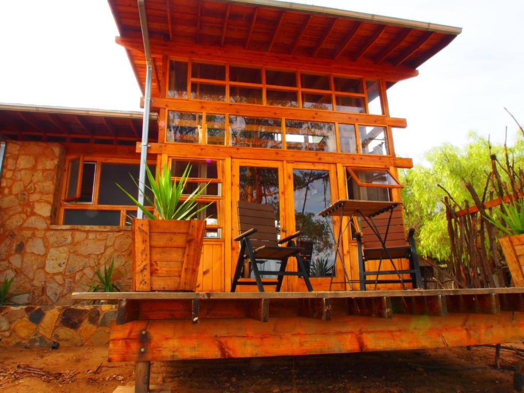 een huis met een veranda en stoelen op een platform bij Casa Mayoral B&B Pet friendly in Valle de Guadalupe