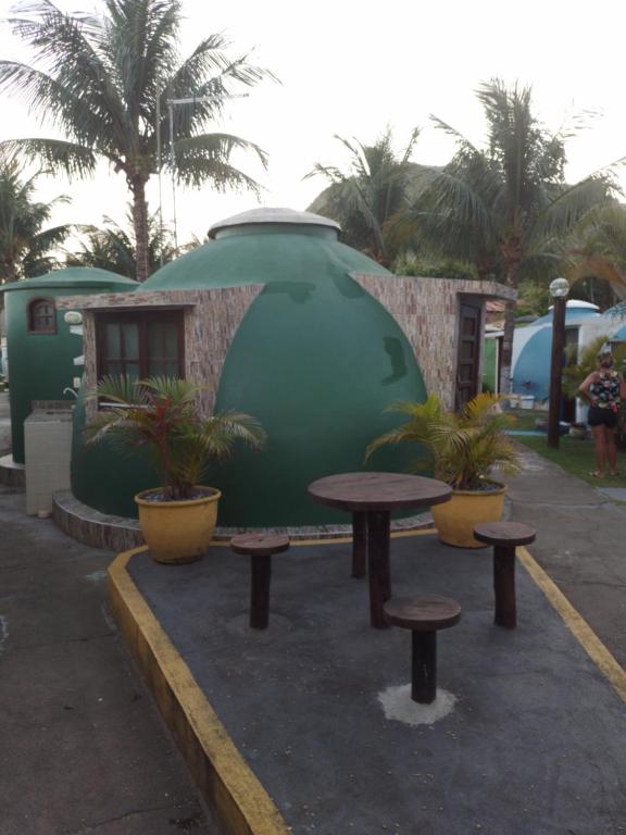 a picnic table and benches in front of a building at Cabana lofft 70 em Tucuns Búzios in Búzios