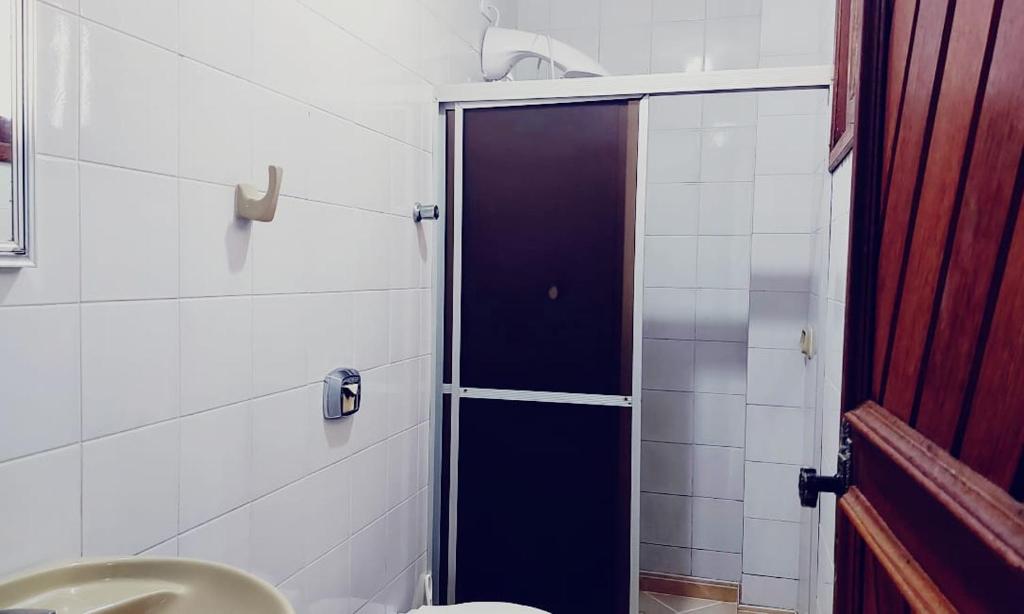 a bathroom with a shower with a toilet and a sink at Apto com Varanda 104 - Balneário Arroio do Silva - 300 metros do Mar in Arroio do Silva