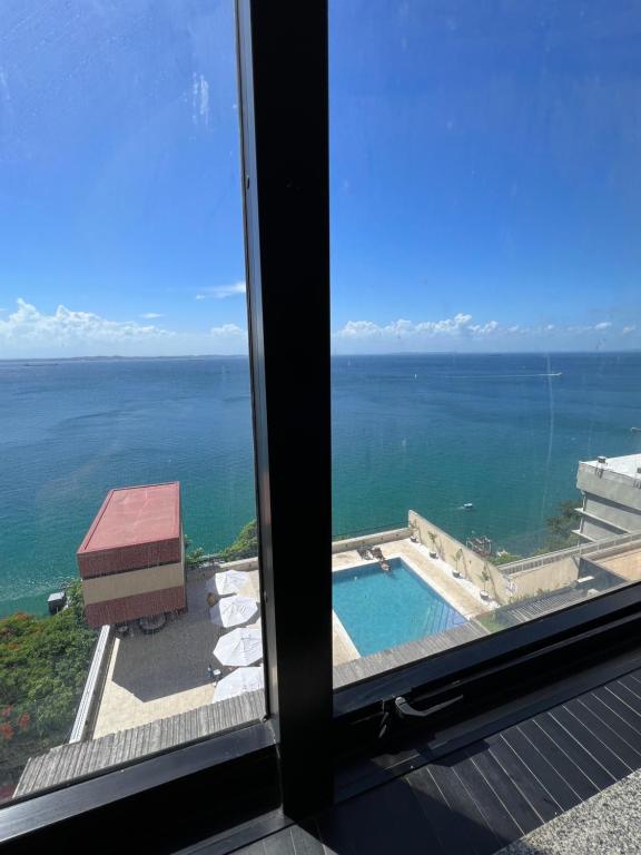 a view of the ocean from a window at Apartamento Vista Mar Salvador - Vista fantástica in Salvador