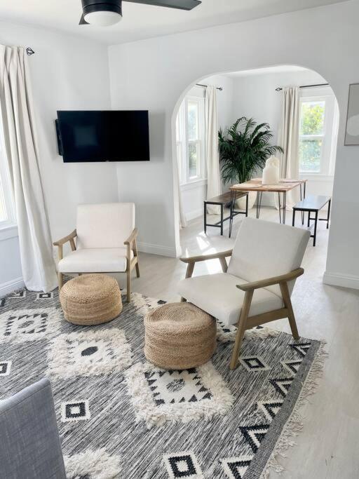 a living room with two white chairs and a rug at Coastal inspired apartment in downtown culver city in Los Angeles