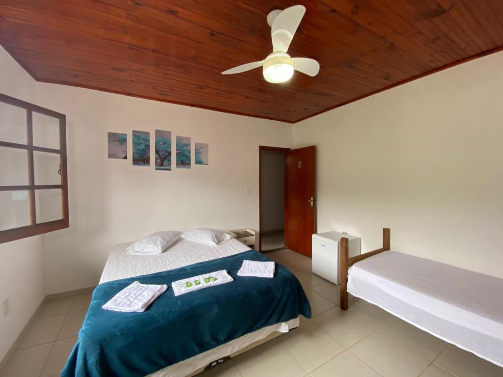 una camera con letto e ventilatore a soffitto di GREENHOUSE Hospedagem a Macaé