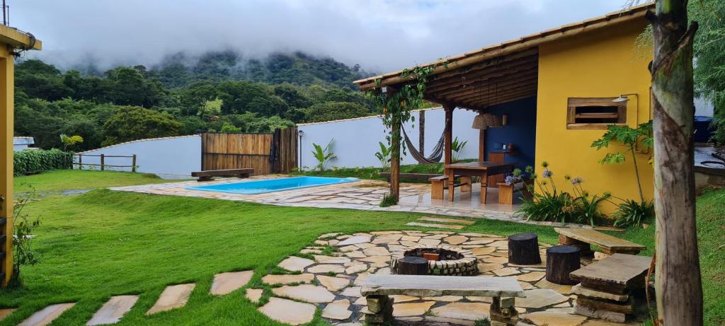 a backyard with a fire pit and a house at Casa de campo em São Thomé das Letras in São Thomé das Letras