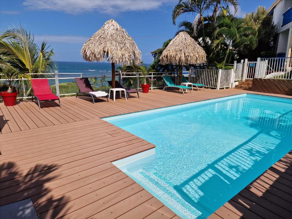 a swimming pool on a deck with a view of the ocean at Hotel Le Manguier in Quartier Morne Pavillon