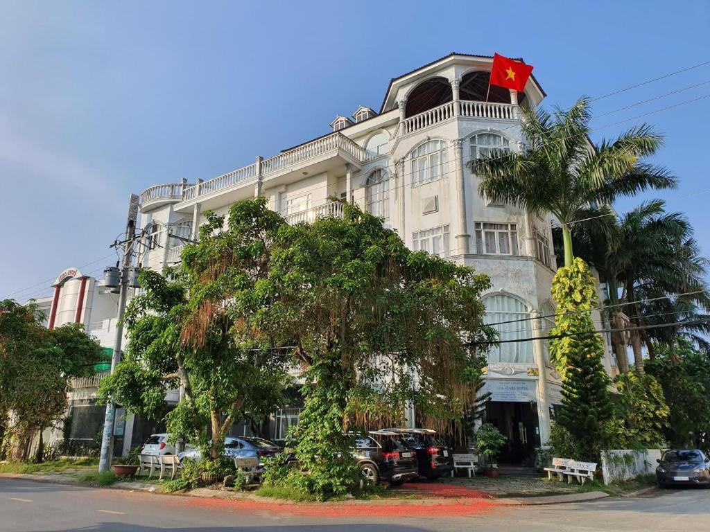 ein großes weißes Gebäude mit einer kanadischen Flagge darauf in der Unterkunft Sea Stars Hotel in Rạch Giá