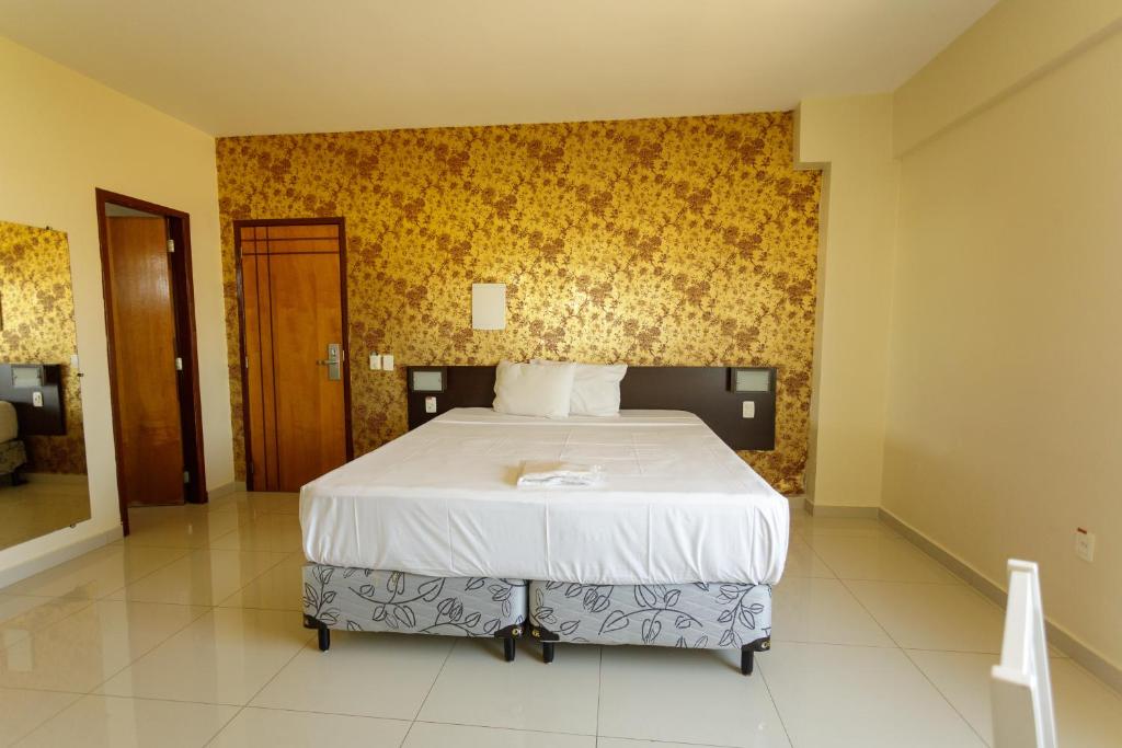 a bedroom with a bed with a yellow wall at Atrium Express Hotels in Parauapebas