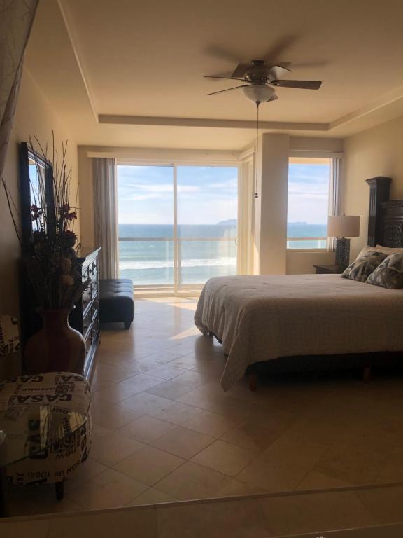 a bedroom with a bed and a view of the ocean at Playa Bonita Rosarito in Rosarito