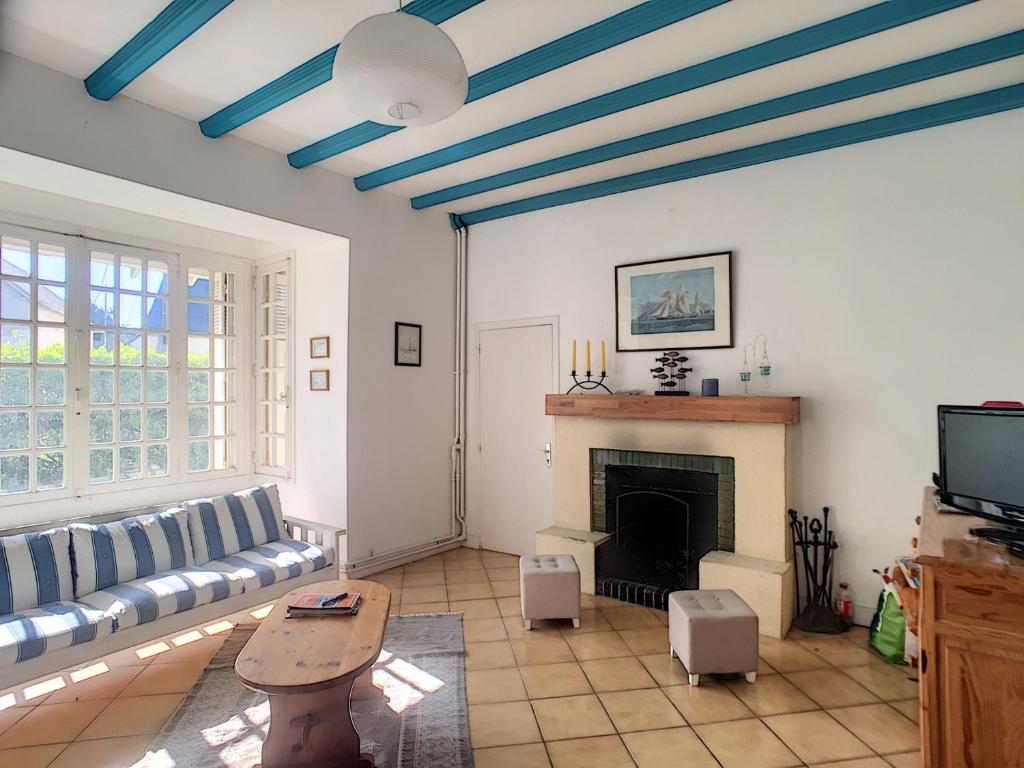 un salon avec un canapé et une cheminée dans l'établissement Maison de Caractère avec Jardin, à 300m de la Plage et Commerces - FR-1-361-60, à Jullouville