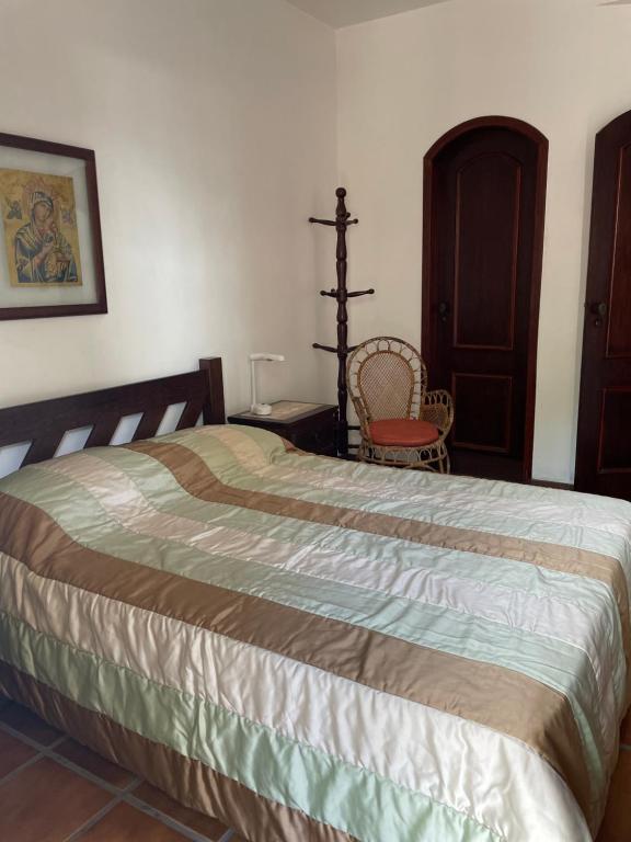 ein Schlafzimmer mit einem großen Bett und einem Stuhl in der Unterkunft Cabo Frio Líder da Praia in Cabo Frio