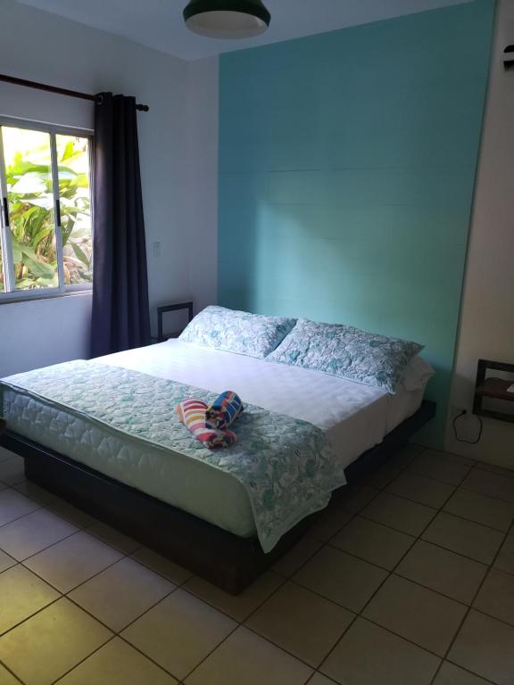 a bedroom with a bed with a doll sitting on it at Cote Pacific Casitas in Huacas