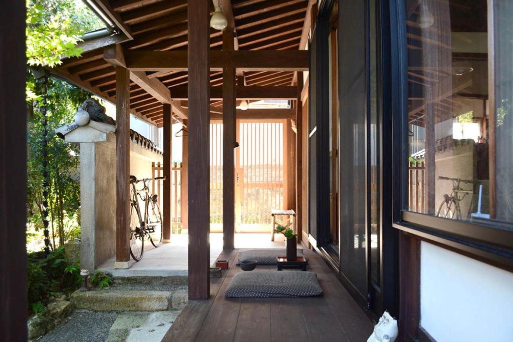 an empty porch of a house with a wooden ceiling at ZOKUIJINKAN GUESTHOUSe 続異人館 in Arita