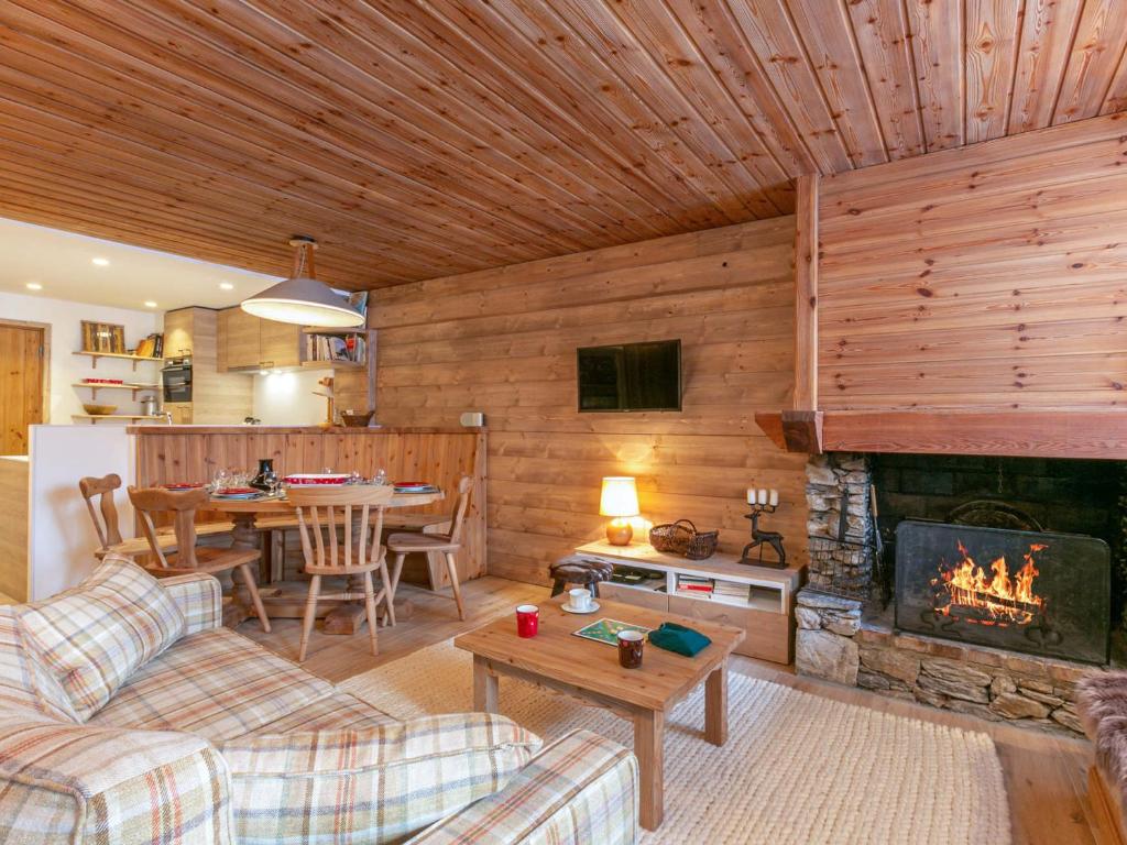 un salon avec une cheminée et une table dans l'établissement Élégant appartement rénové avec wifi au cœur du vieux Val-d'Isère, proche des pistes et commodités - FR-1-694-313, à Val dʼIsère