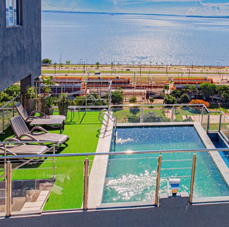 a swimming pool on a balcony with a view of the ocean at 25 homeApart in Encarnación