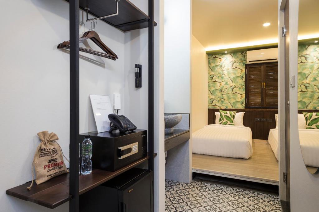 A compact bedroom viewed through an open wardrobe and entry area.