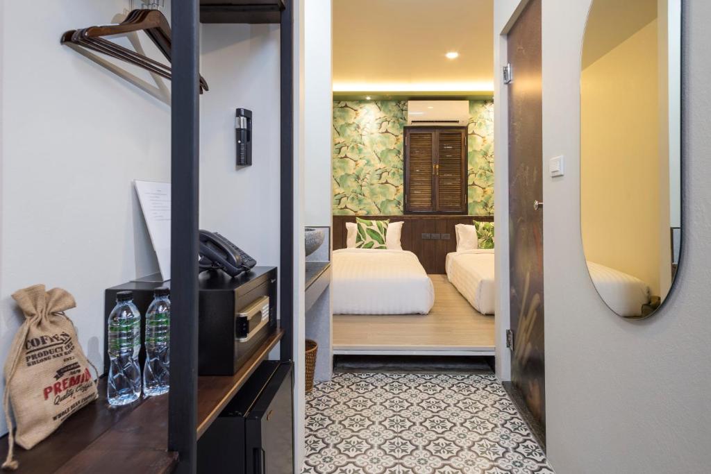 A compact room entry with open storage and a view toward twin beds.