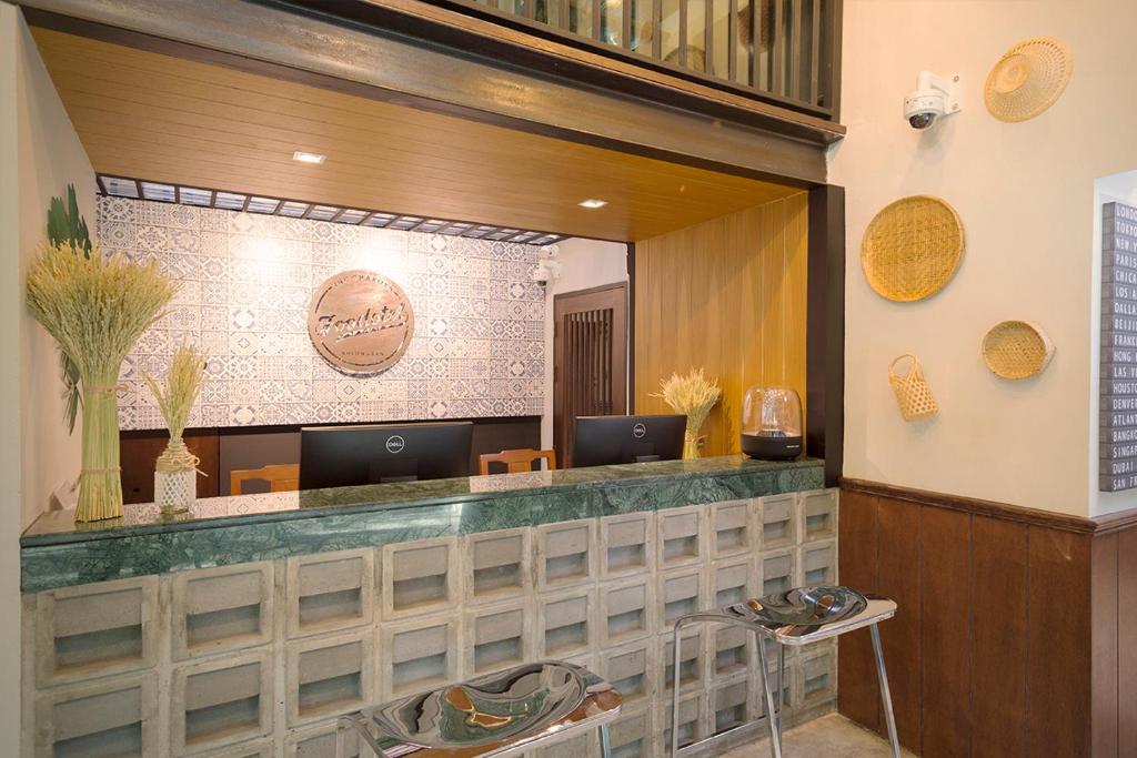 A compact reception desk with two computer stations and decorative Thai-inspired details.