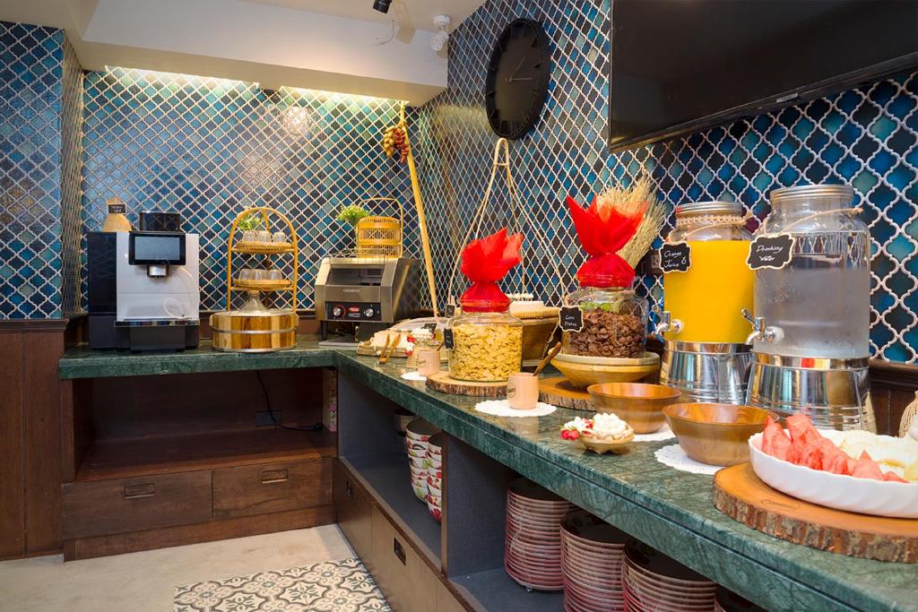 A close view of the breakfast buffet with drinks, fruit, pastries and serving equipment.