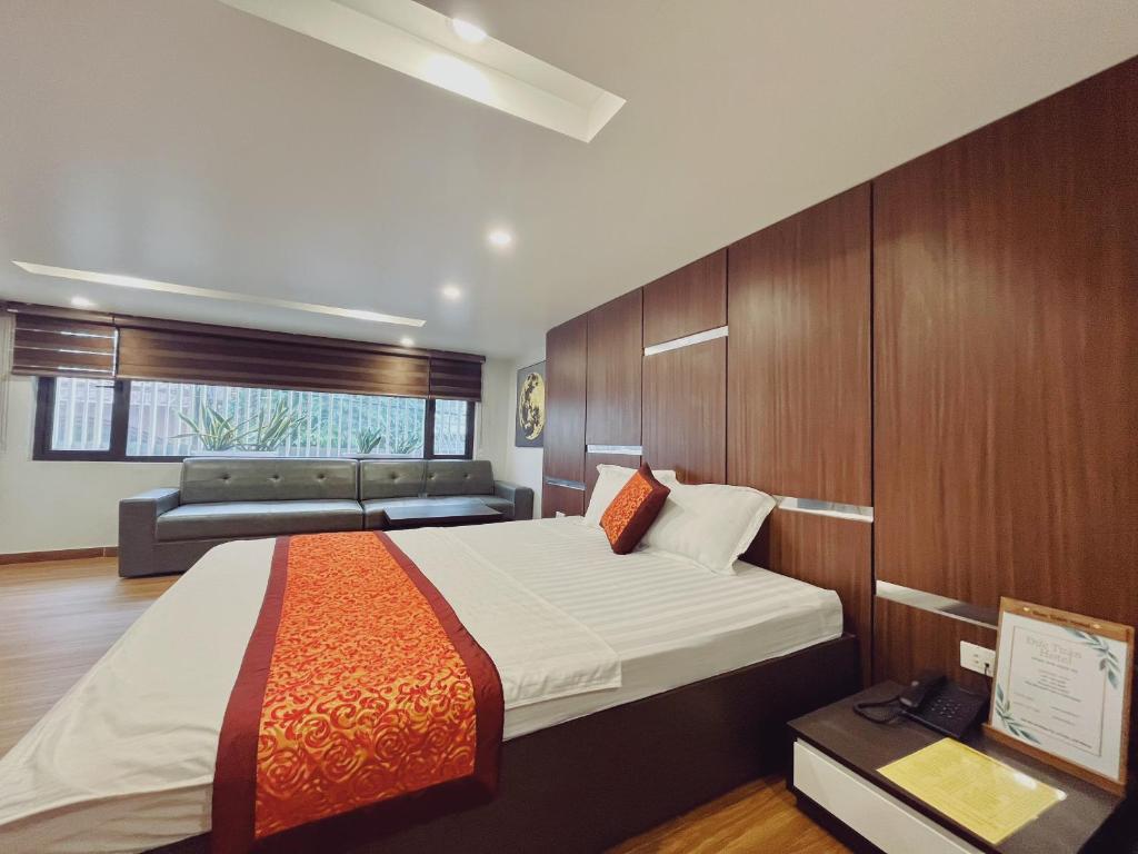 a bedroom with a large bed and a couch at DT Hotel Hai Phong in Hai Phong