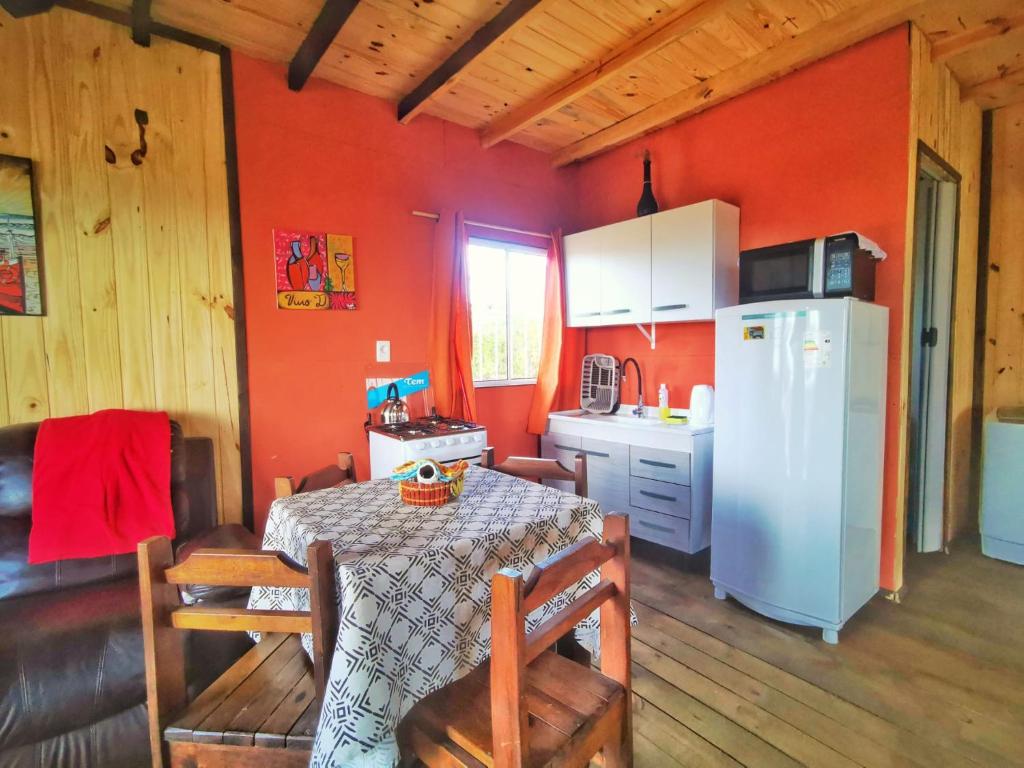 uma cozinha com uma mesa e um frigorífico branco em Veniteconmigo em Punta Del Diablo